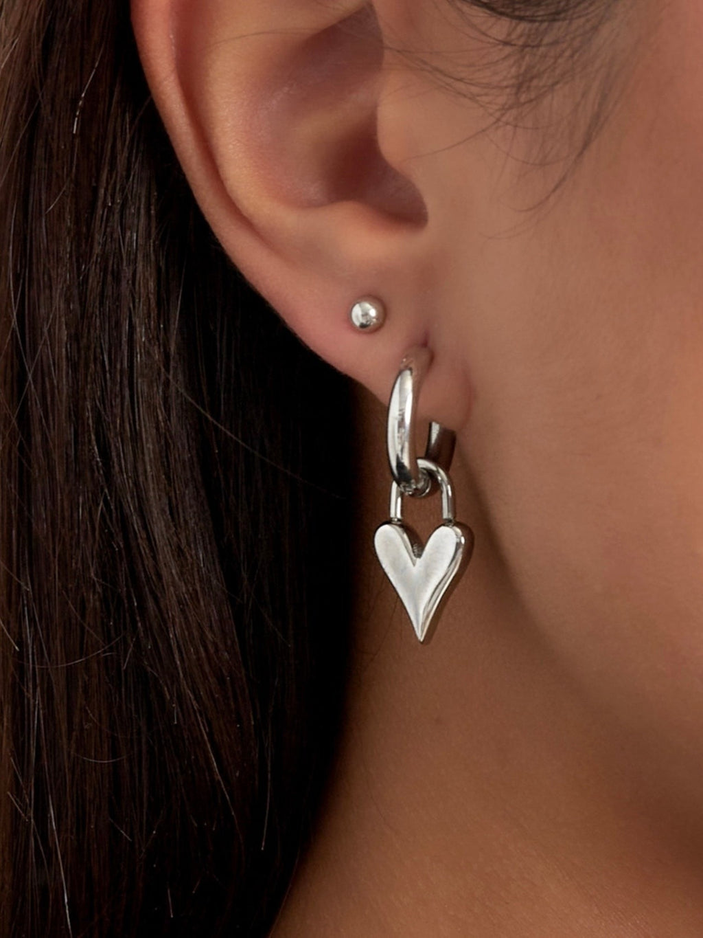 WILDSIDE silver-tone metal hoop earrings with a dangling dimensional heart charm. Perfect for everyday wear.