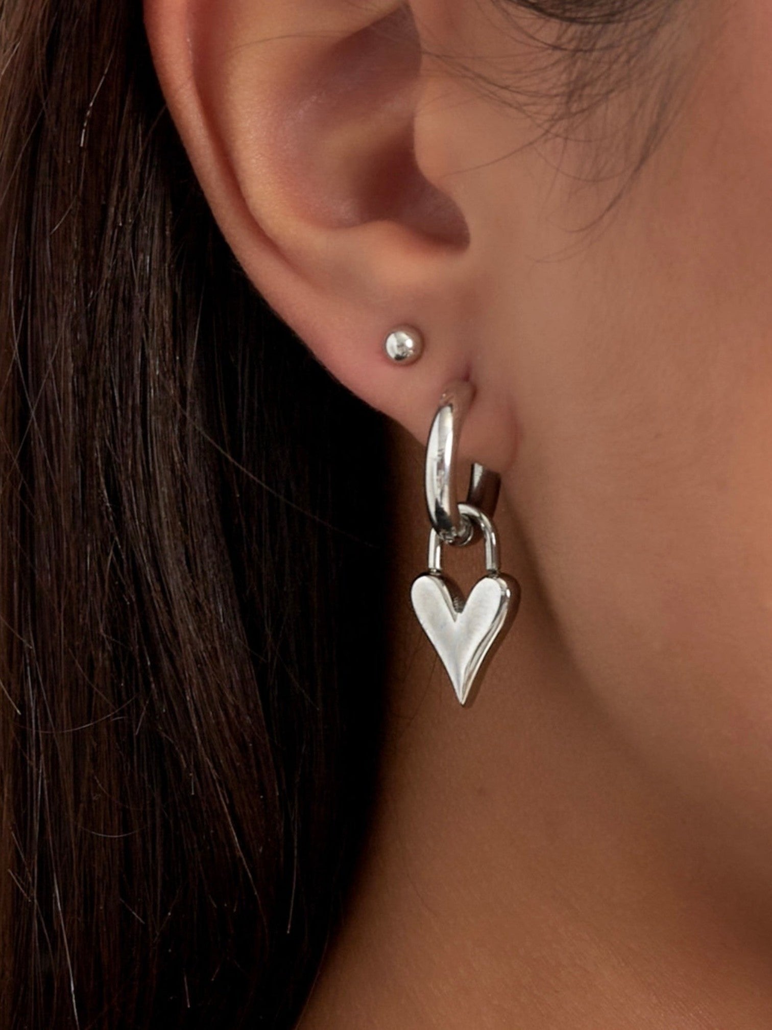WILDSIDE silver-tone metal hoop earrings with a dangling dimensional heart charm. Perfect for everyday wear.