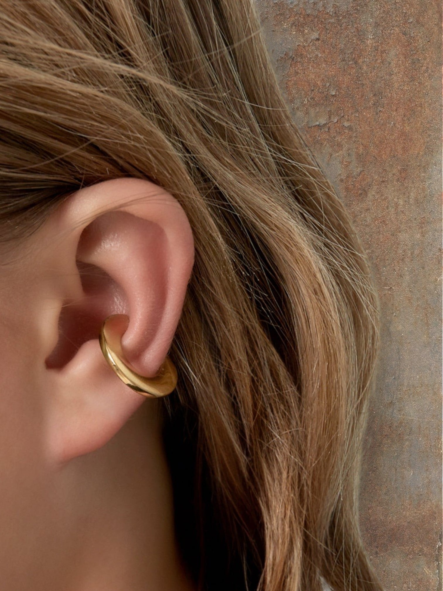 WILDSIDE polished gold metal curved ear cuff, a minimalist accessory for non-pierced ears.