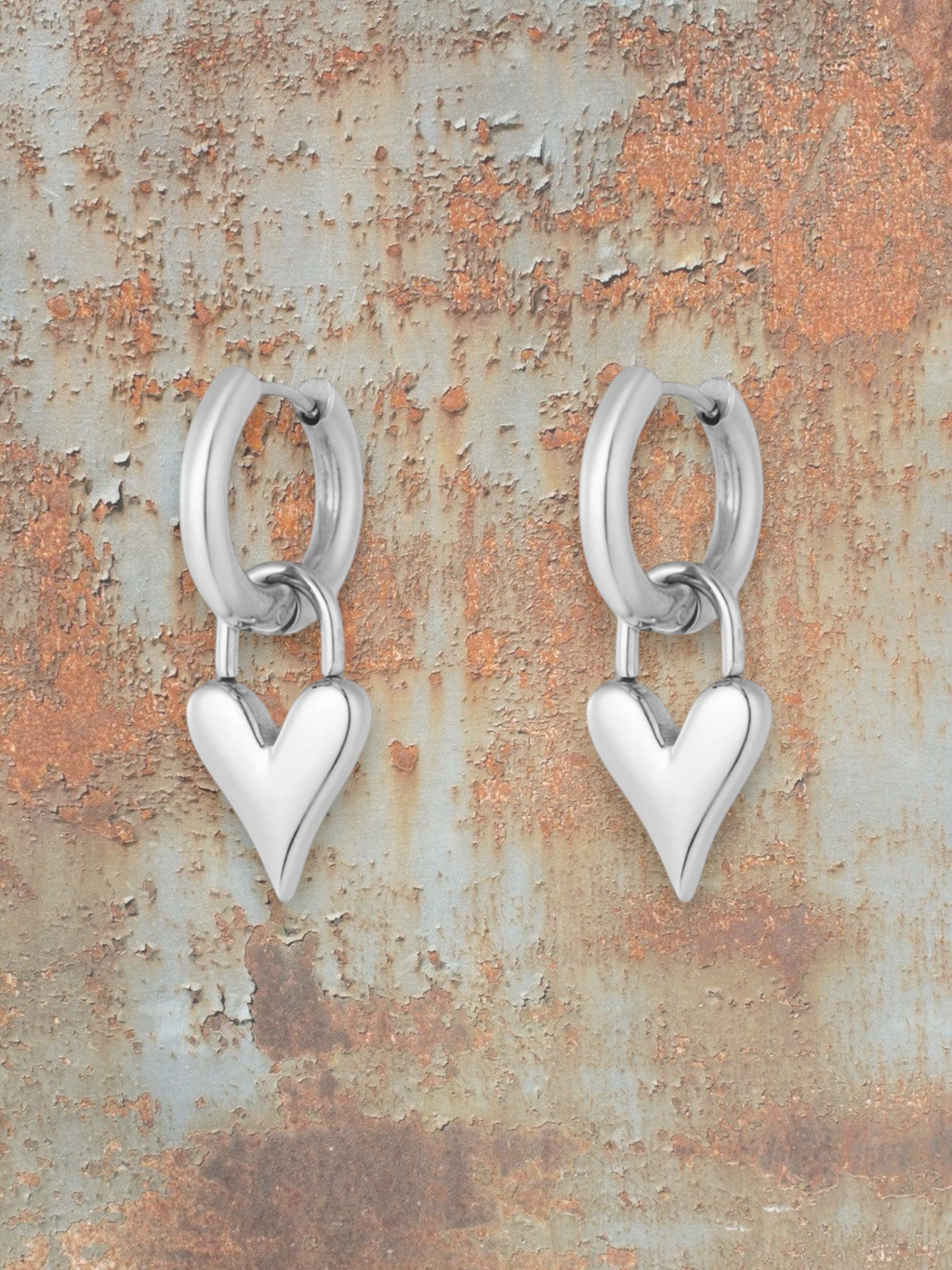 WILDSIDE silver-tone metal hoop earrings with dangling dimensional heart charms. Perfect for everyday wear.
