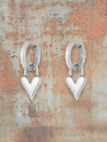 WILDSIDE silver-tone metal hoop earrings with dangling dimensional heart charms. Perfect for everyday wear.