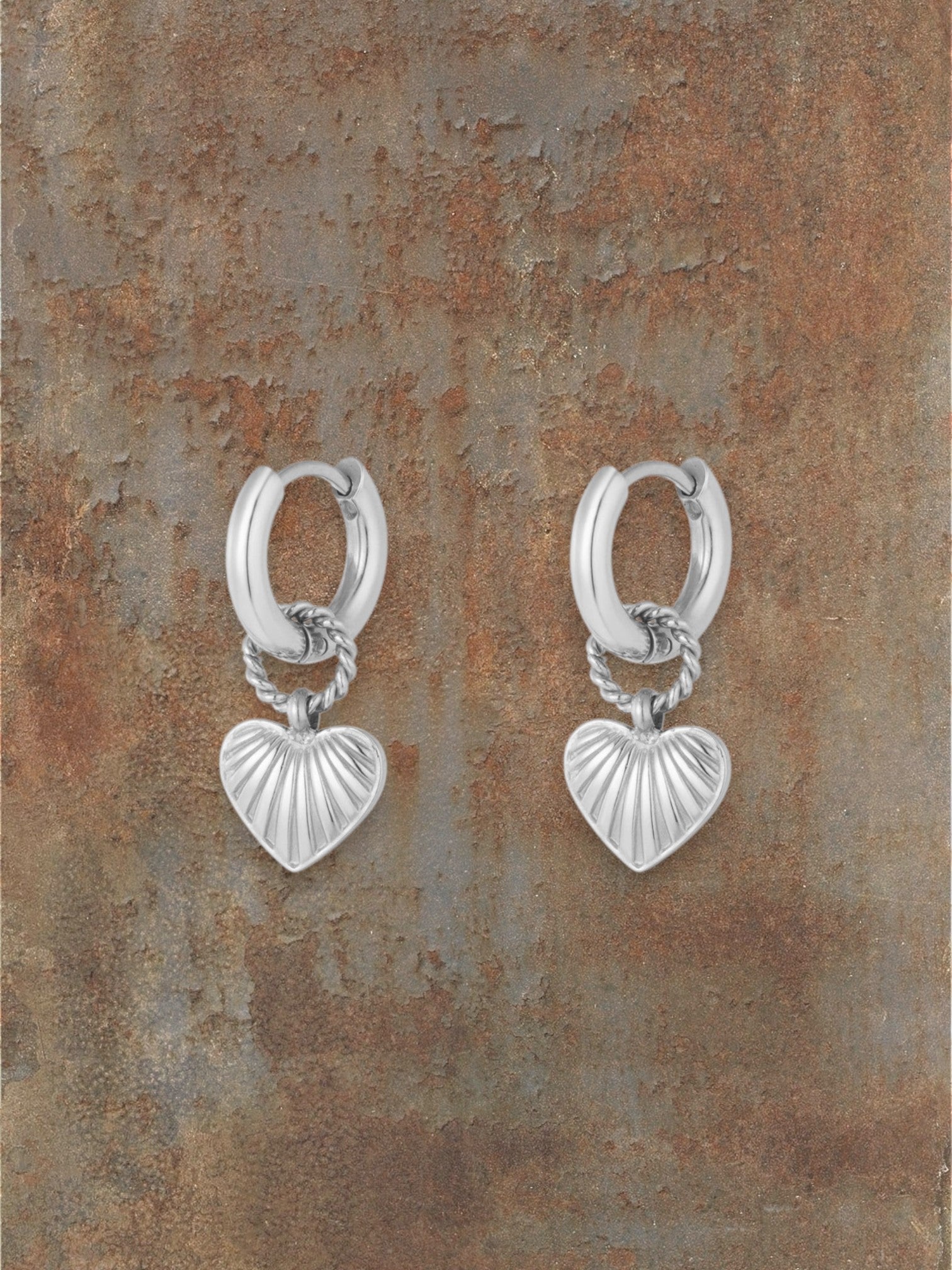 WILDSIDE silver metal textured heart hoop earrings with ridged pendant and twisted rope detail.