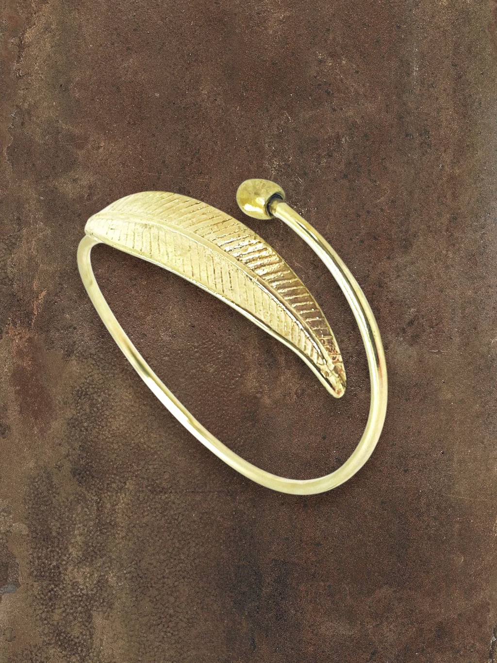 WILDSIDE polished brass open cuff bracelet with a detailed leaf design and adjustable fit.