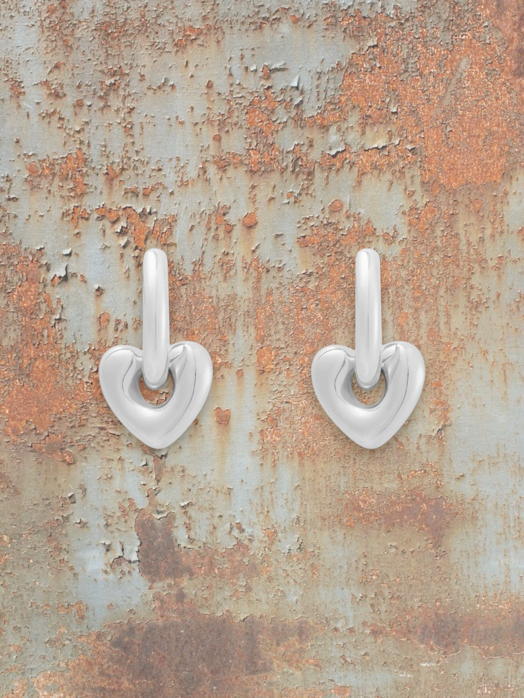 WILDSIDE polished silver steel heart shaped drop earrings with sleek hoops.