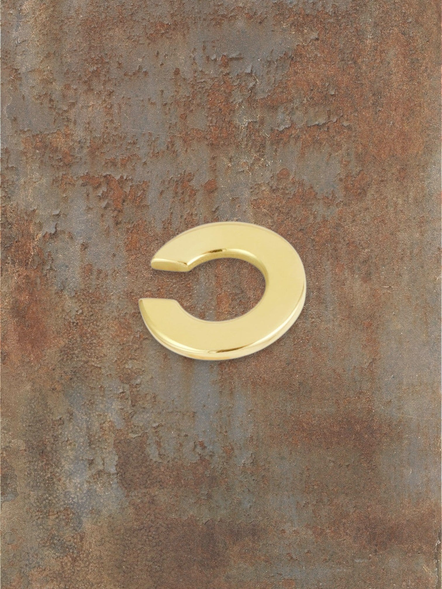 WILDSIDE polished gold-tone metal curved ear cuff, a minimalist and sophisticated accessory.