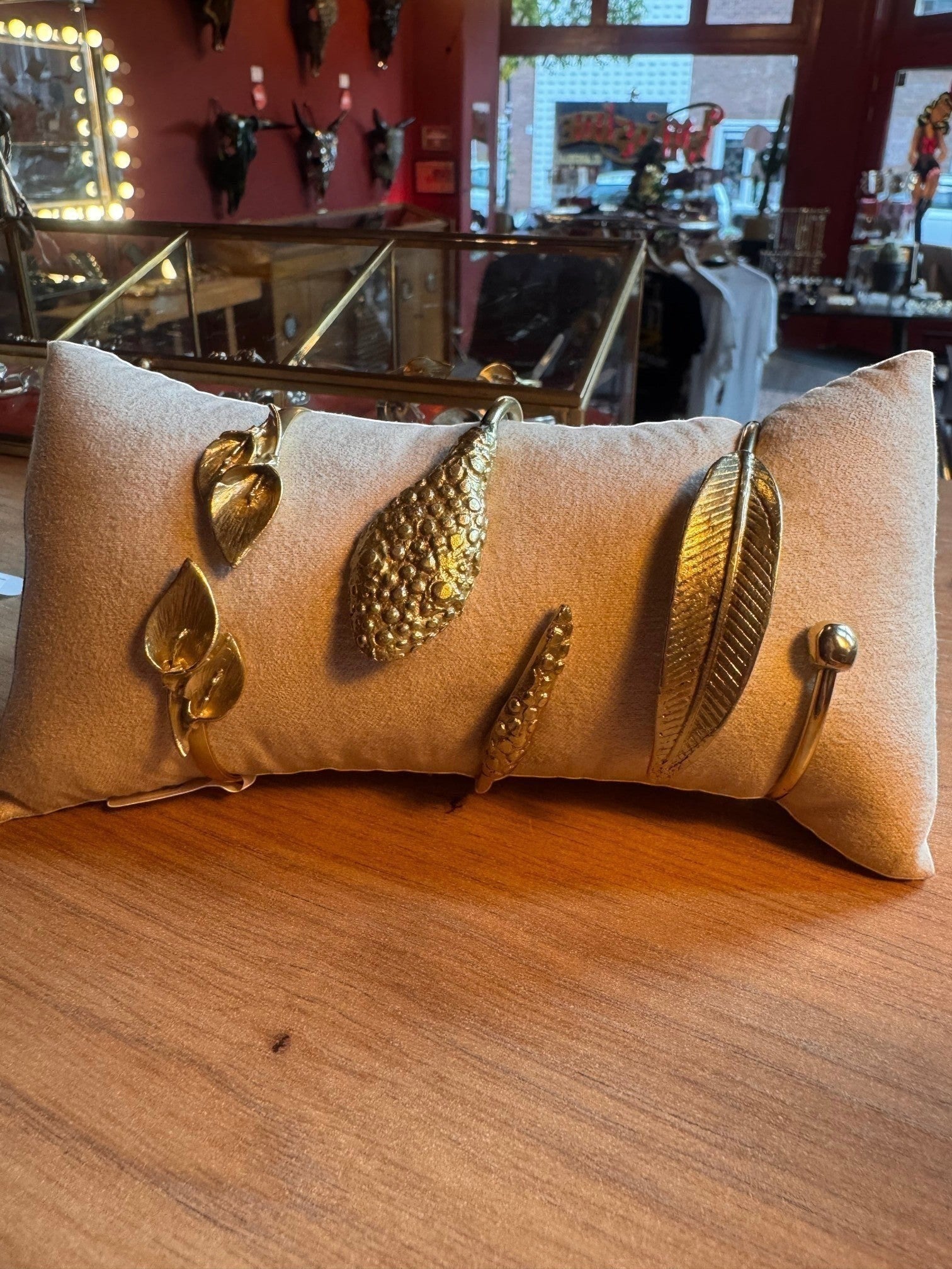 WILDSIDE golden open cuff bracelet with realistic leaf motifs and a feather design. Elegant botanical jewelry.