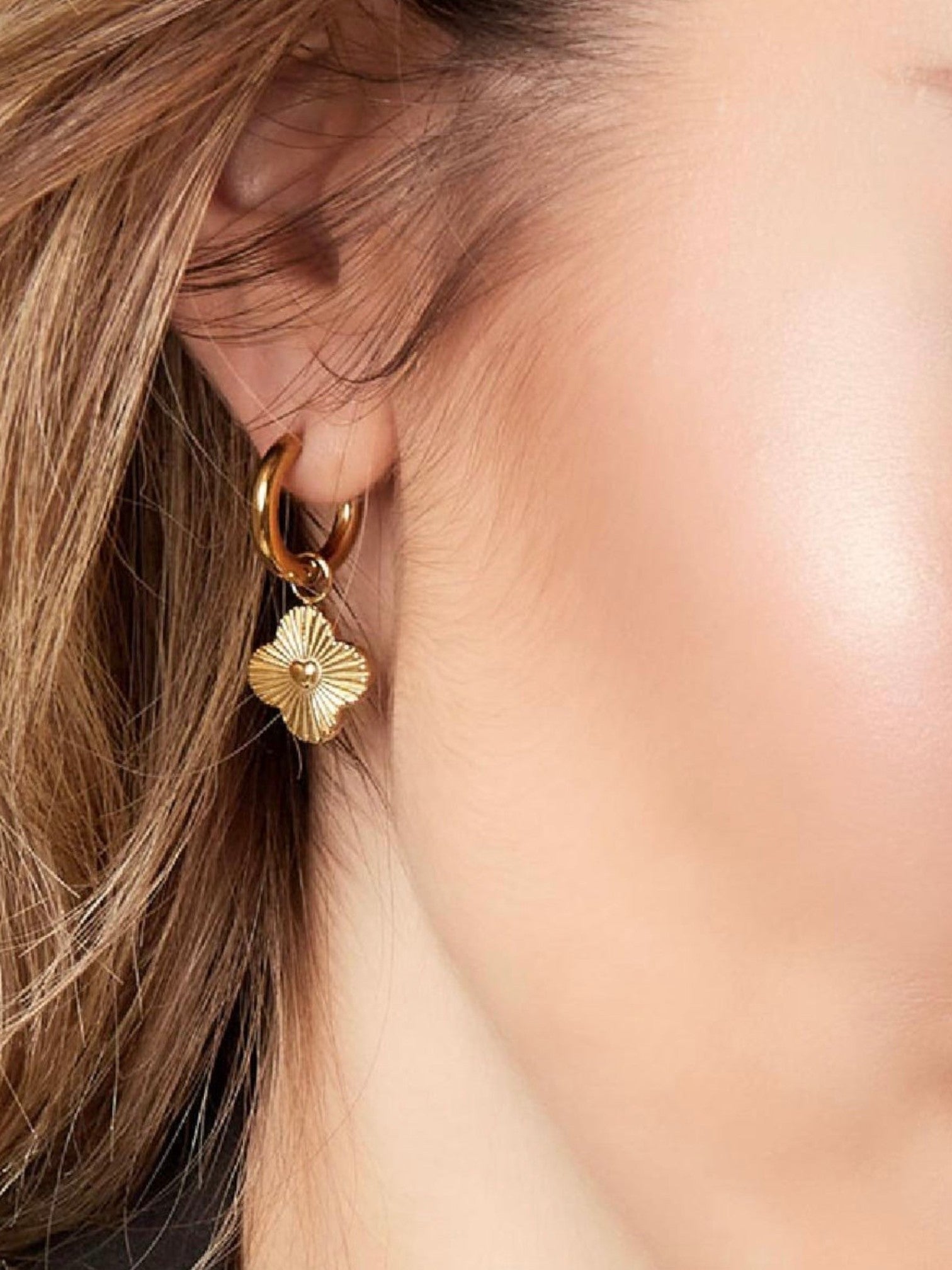 WILDSIDE gold stainless steel hoop earrings with clover heart charm, detailed with radiating lines.