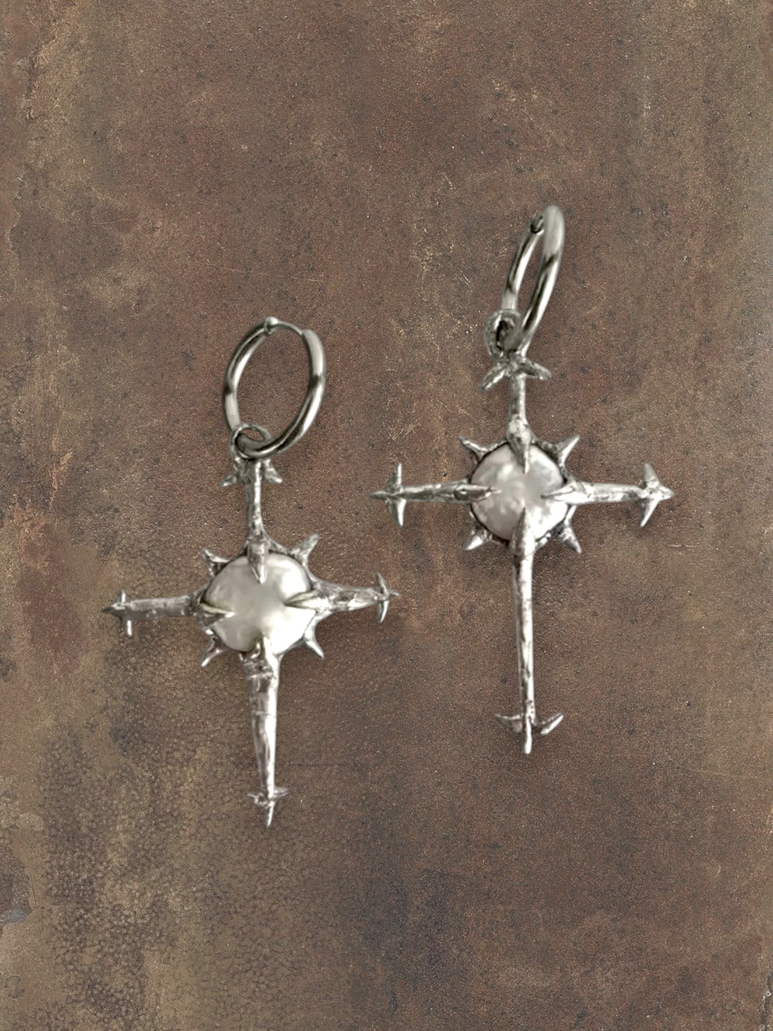 WILDSIDE silver cross earrings with pearl center and star-like points.