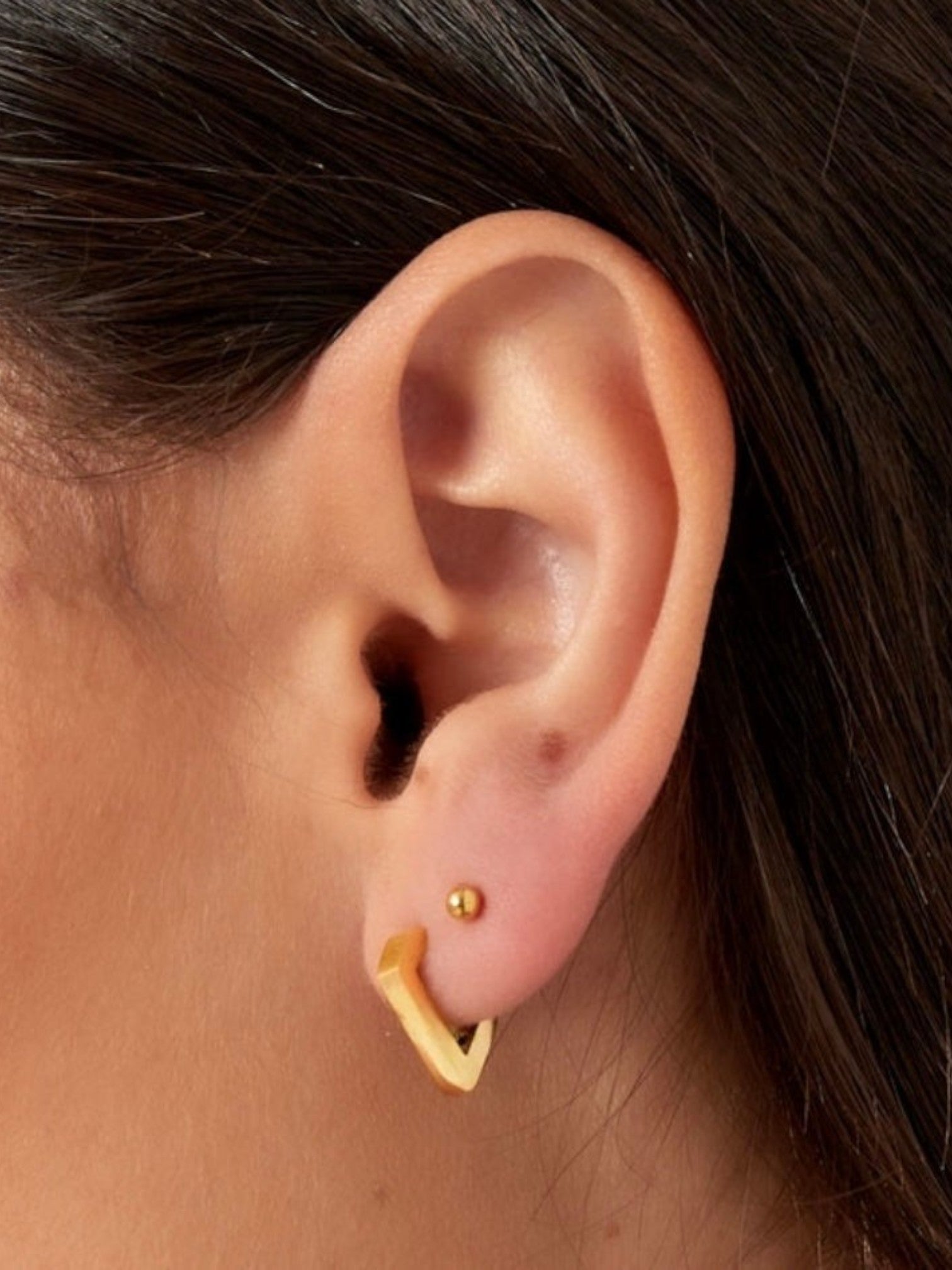 WILDSIDE gold geometric diamond hoop earrings with a polished finish and a small stud earring.