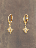 WILDSIDE gold hoop earrings with sparkling star-shaped pendants adorned with clear crystals.