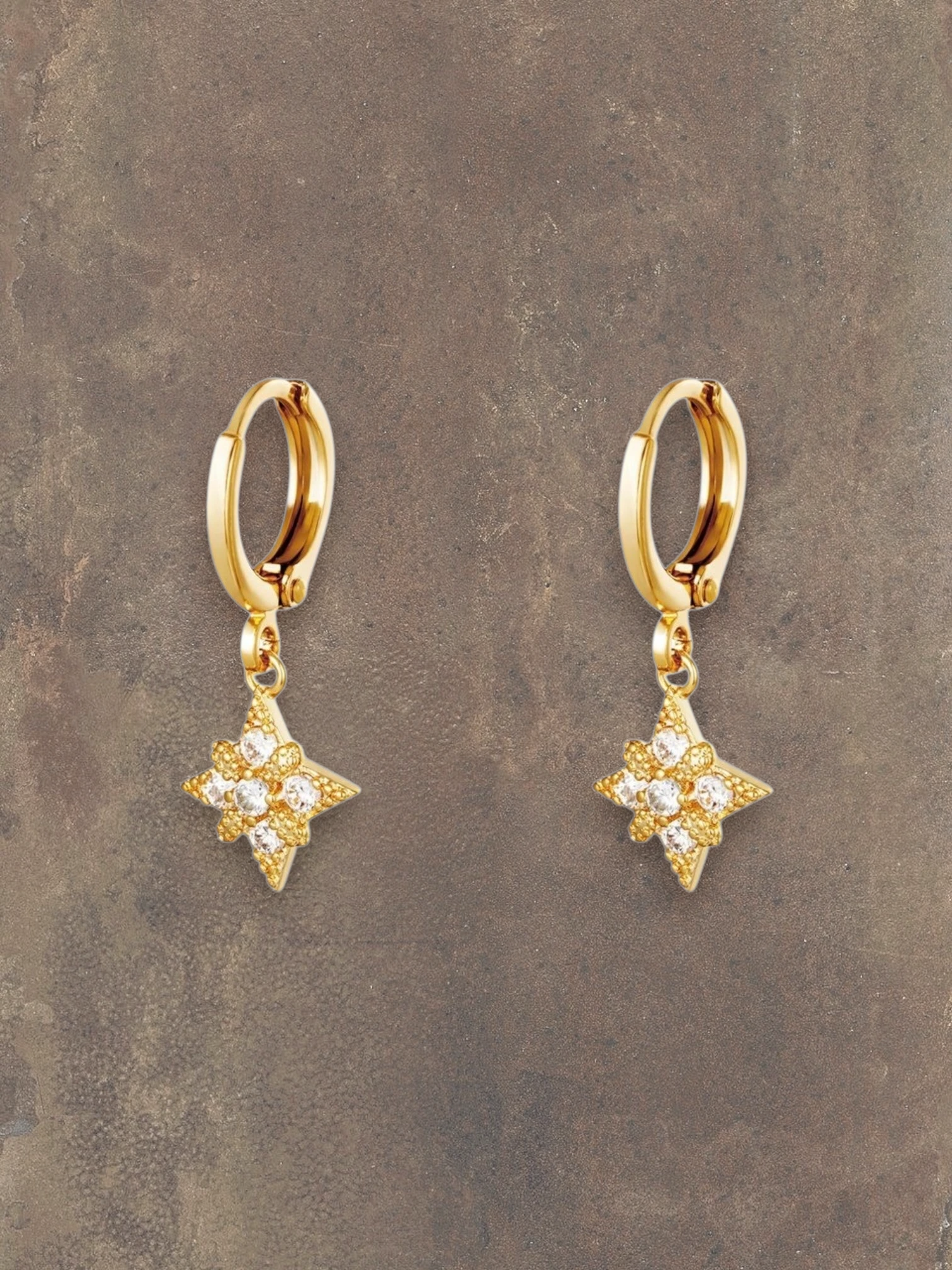 WILDSIDE gold hoop earrings with sparkling star-shaped pendants adorned with clear crystals.