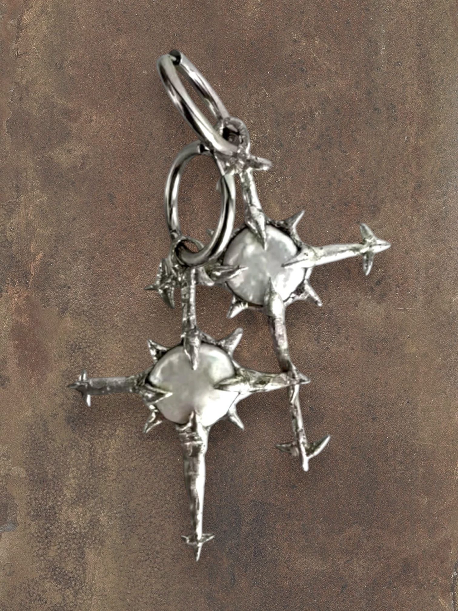 WILDSIDE silver celestial cross earrings with luminous pearls and star-like points.