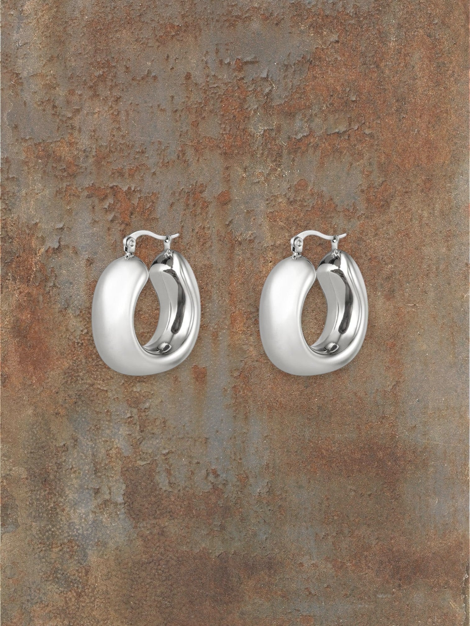 WILDSIDE polished silver steel sculptural hoop earrings with a rounded silhouette for modern elegance.