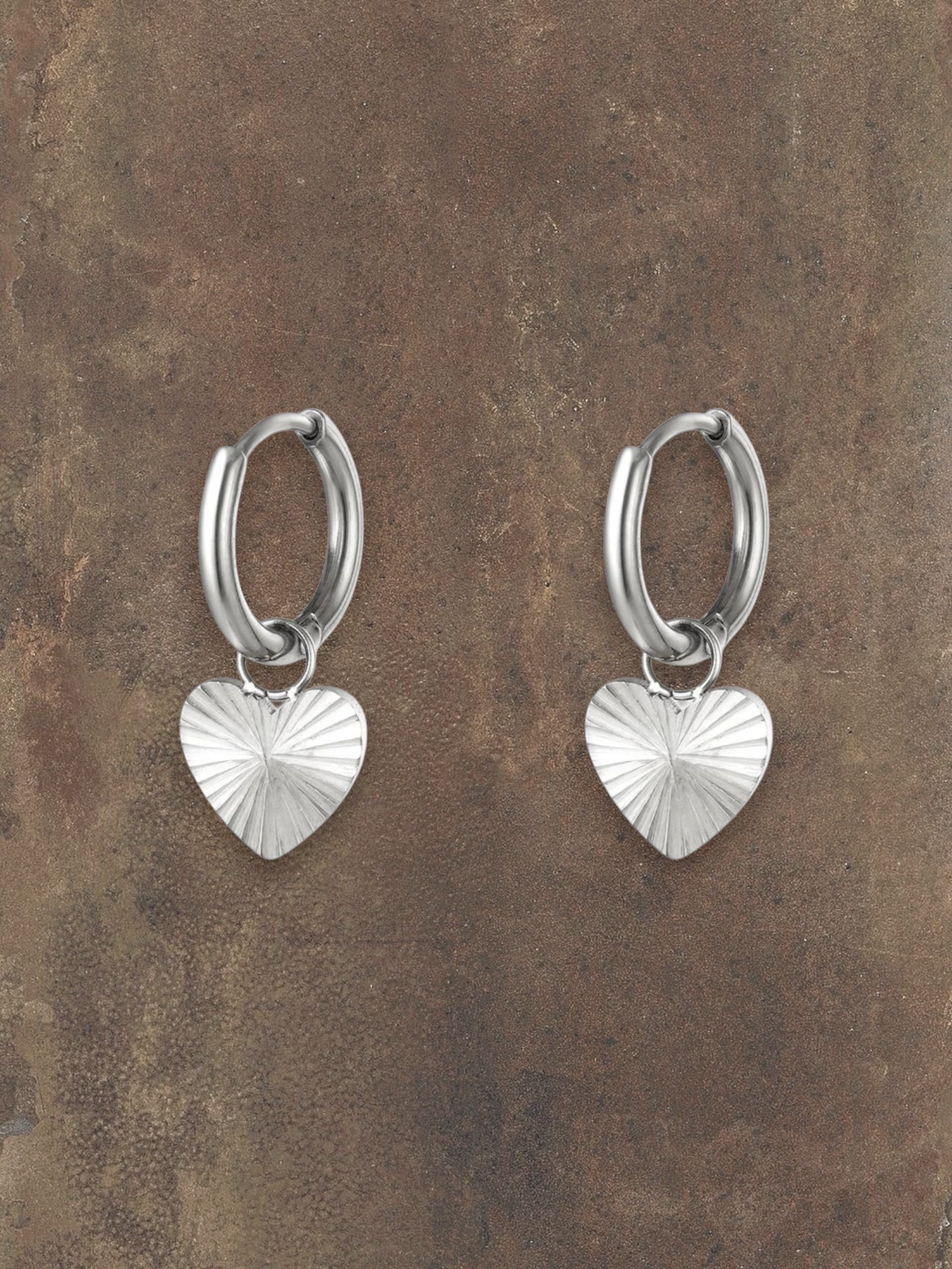 WILDSIDE silver-tone metal hoop earrings with textured heart charms. Perfect for everyday wear.