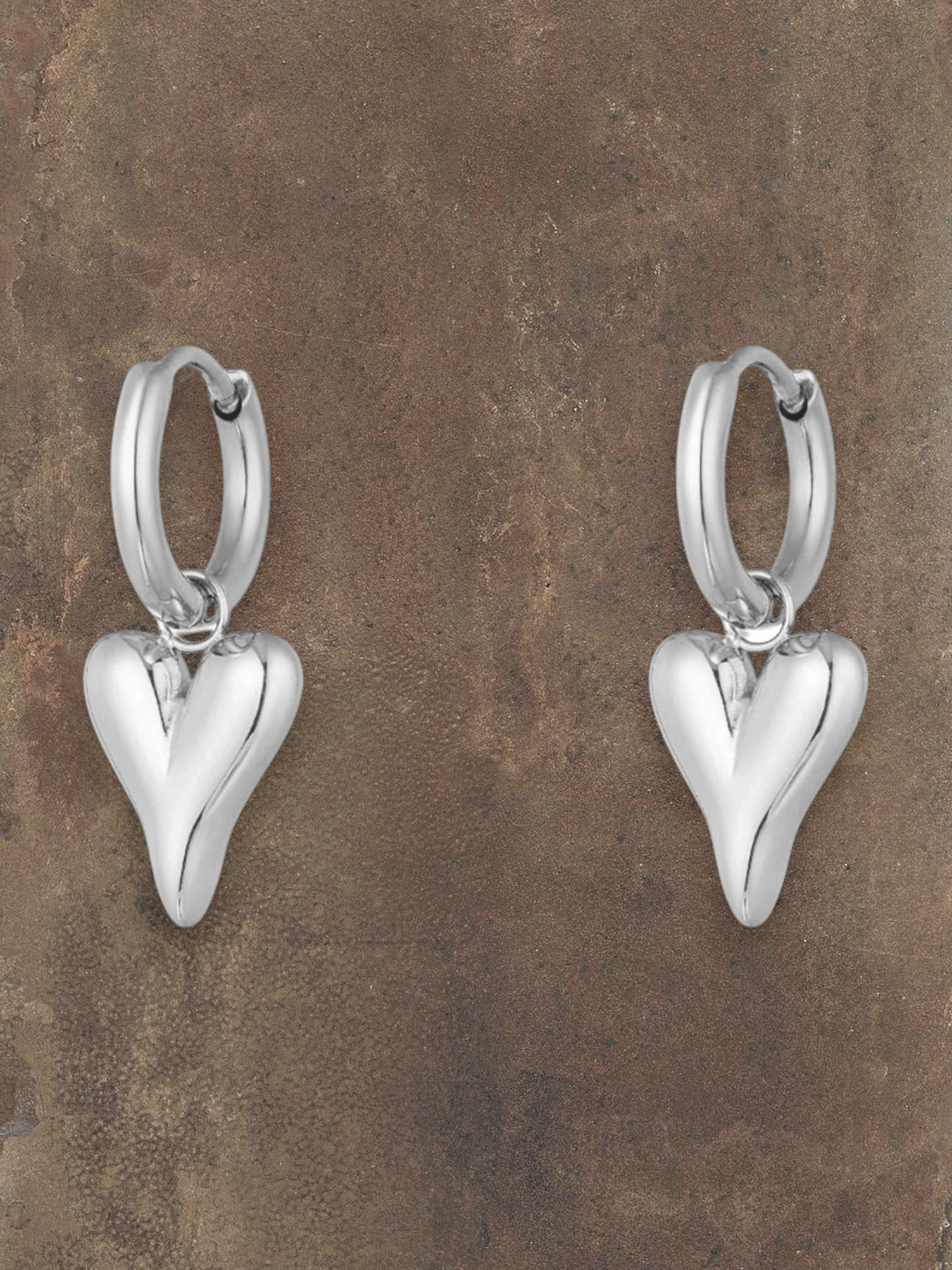 WILDSIDE silver steel puffy heart hoop earrings with polished finish. Classic hoops with dangling heart charms.