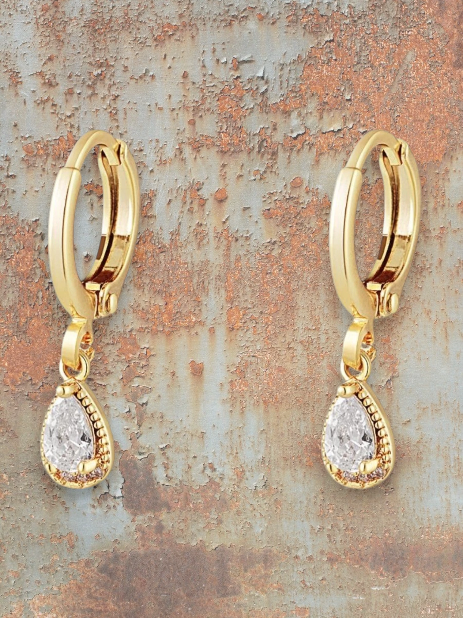 WILDSIDE gold-tone hoop earrings with clear teardrop gemstone pendants and vintage detailing.