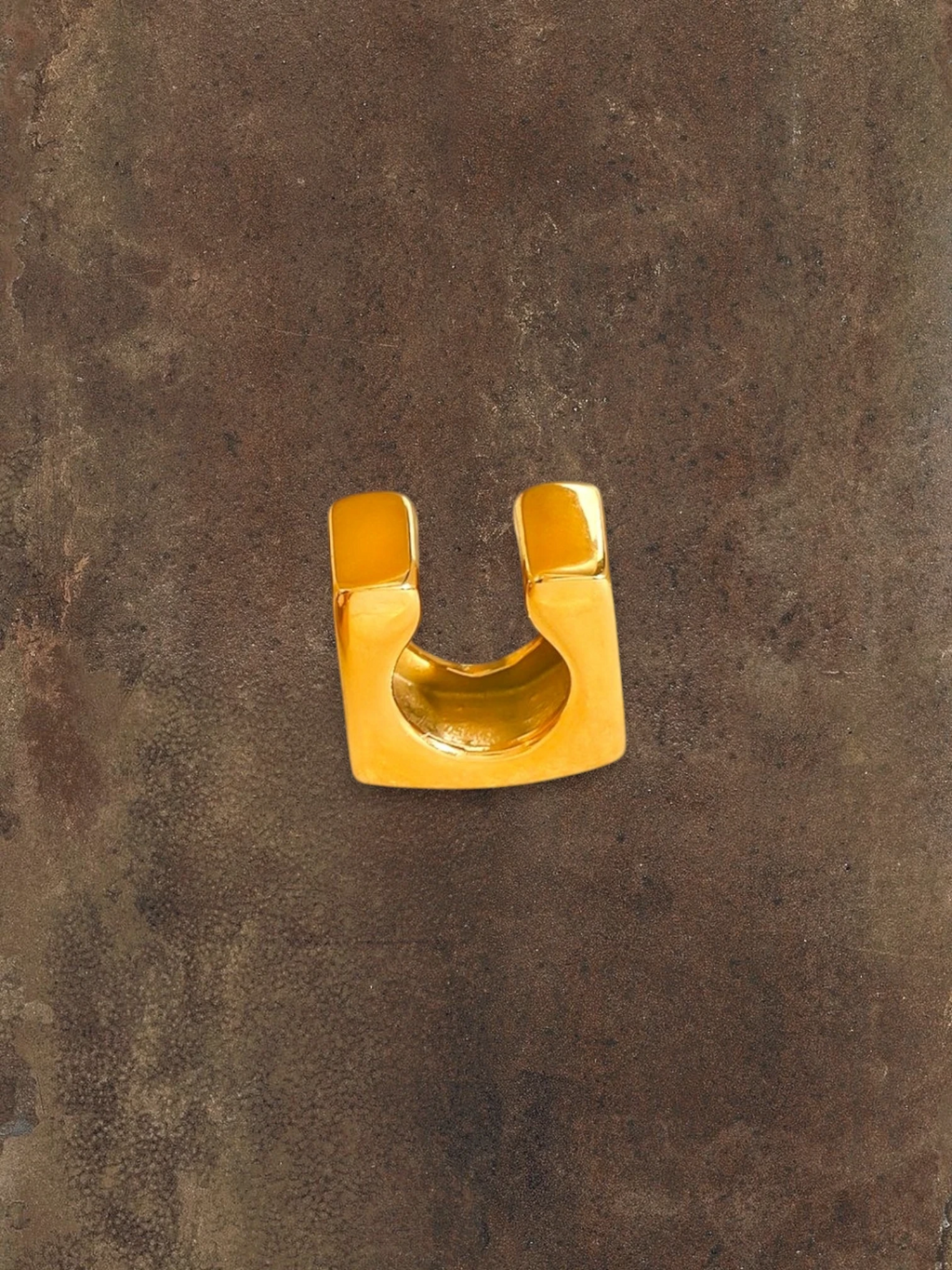 WILDSIDE statement gold ear cuff, a bold, polished metal accessory that slides on without piercing.