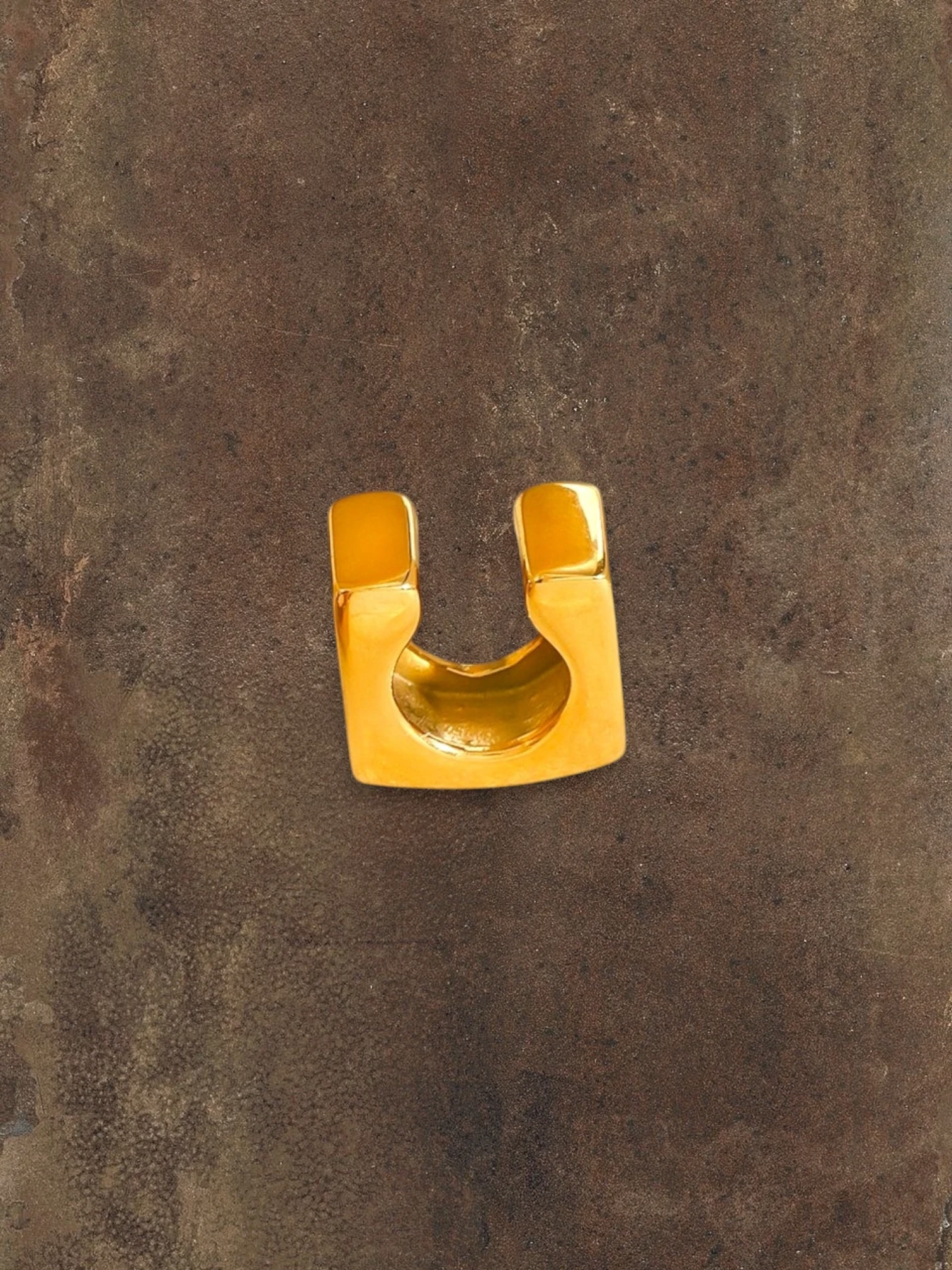 WILDSIDE statement gold ear cuff, a bold, polished metal accessory that slides on without piercing.