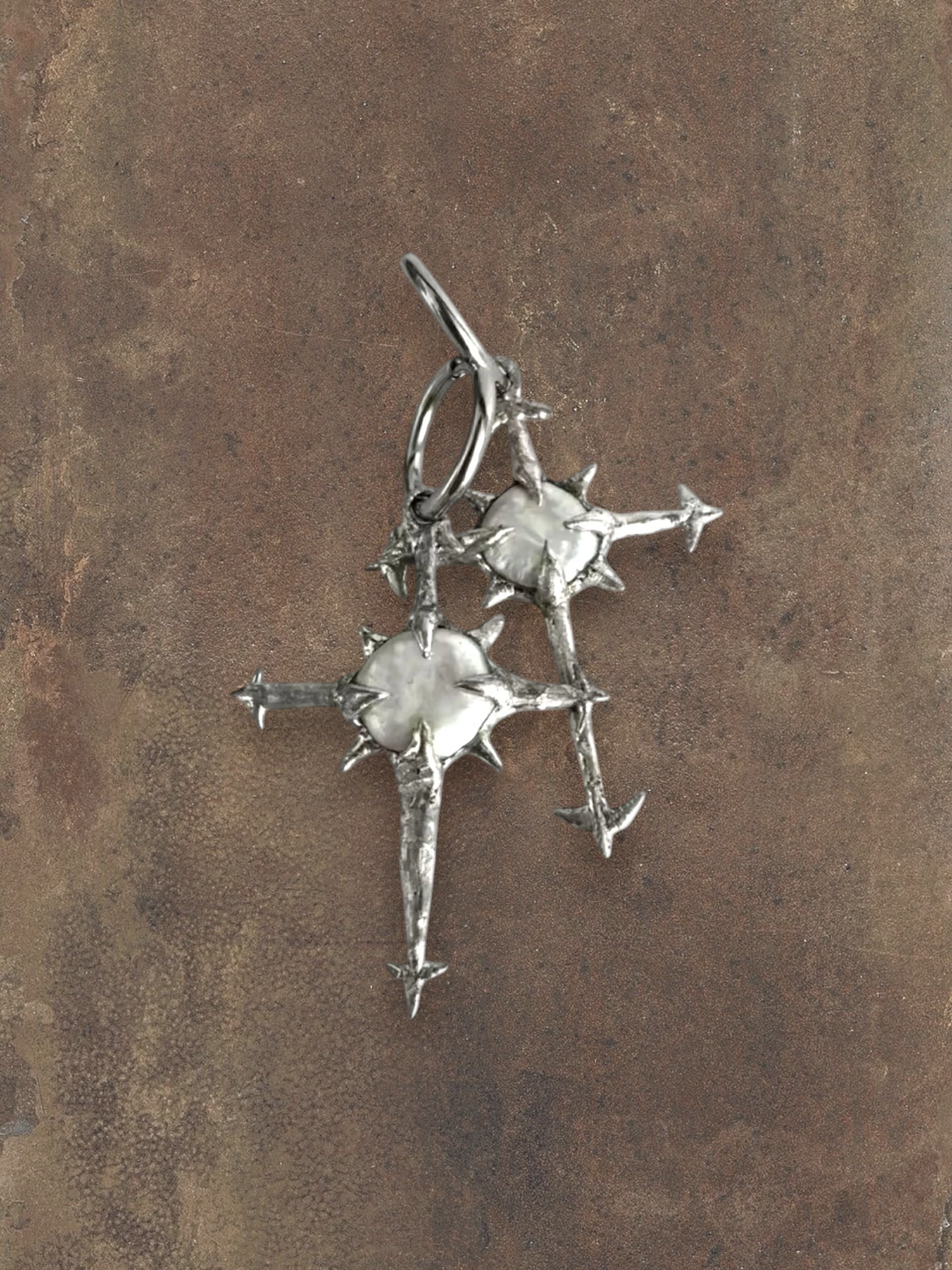 WILDSIDE silver celestial cross earrings with pearl centers and star-like points.