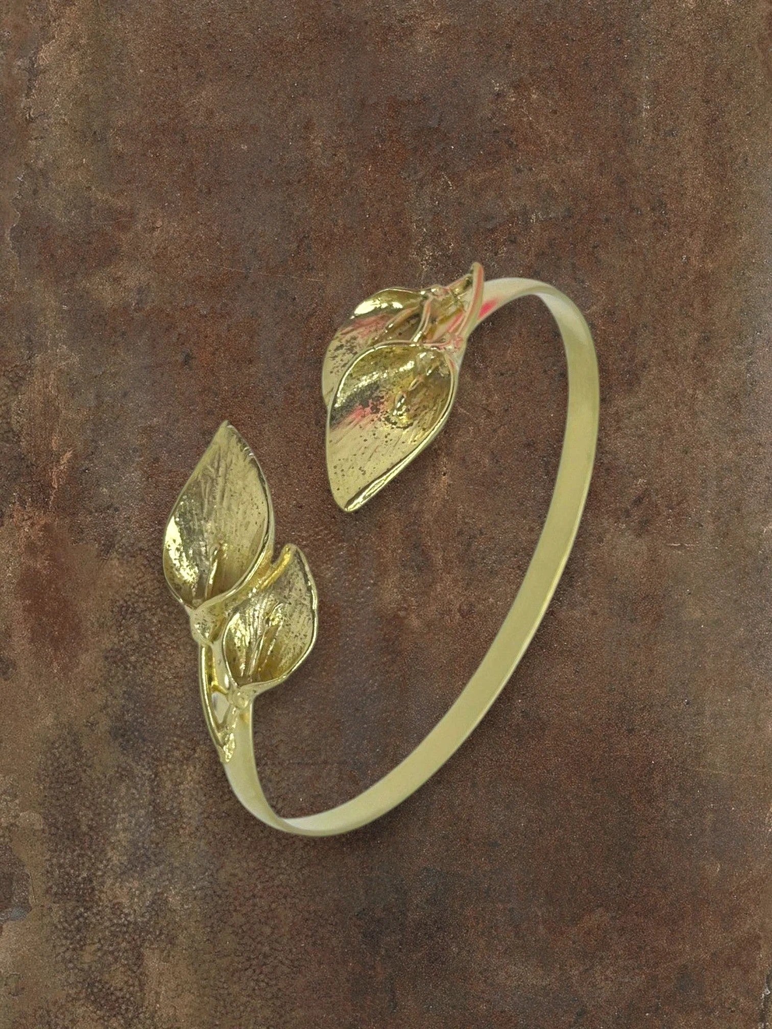 WILDSIDE gold-tone open cuff bracelet with realistic leaf motifs. Elegant botanical statement jewelry.
