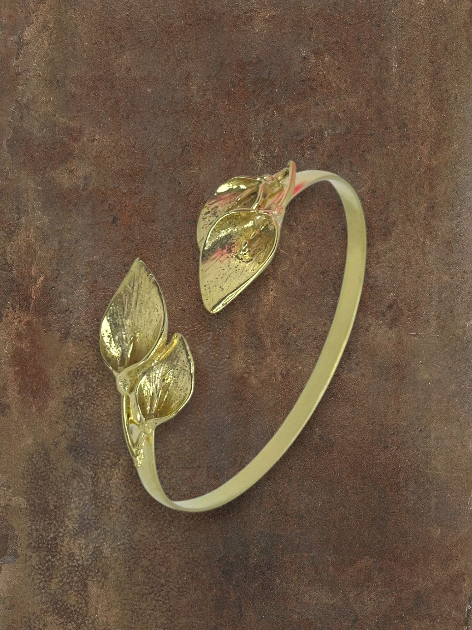 WILDSIDE gold-tone open cuff bracelet with realistic leaf motifs. Elegant botanical statement jewelry.
