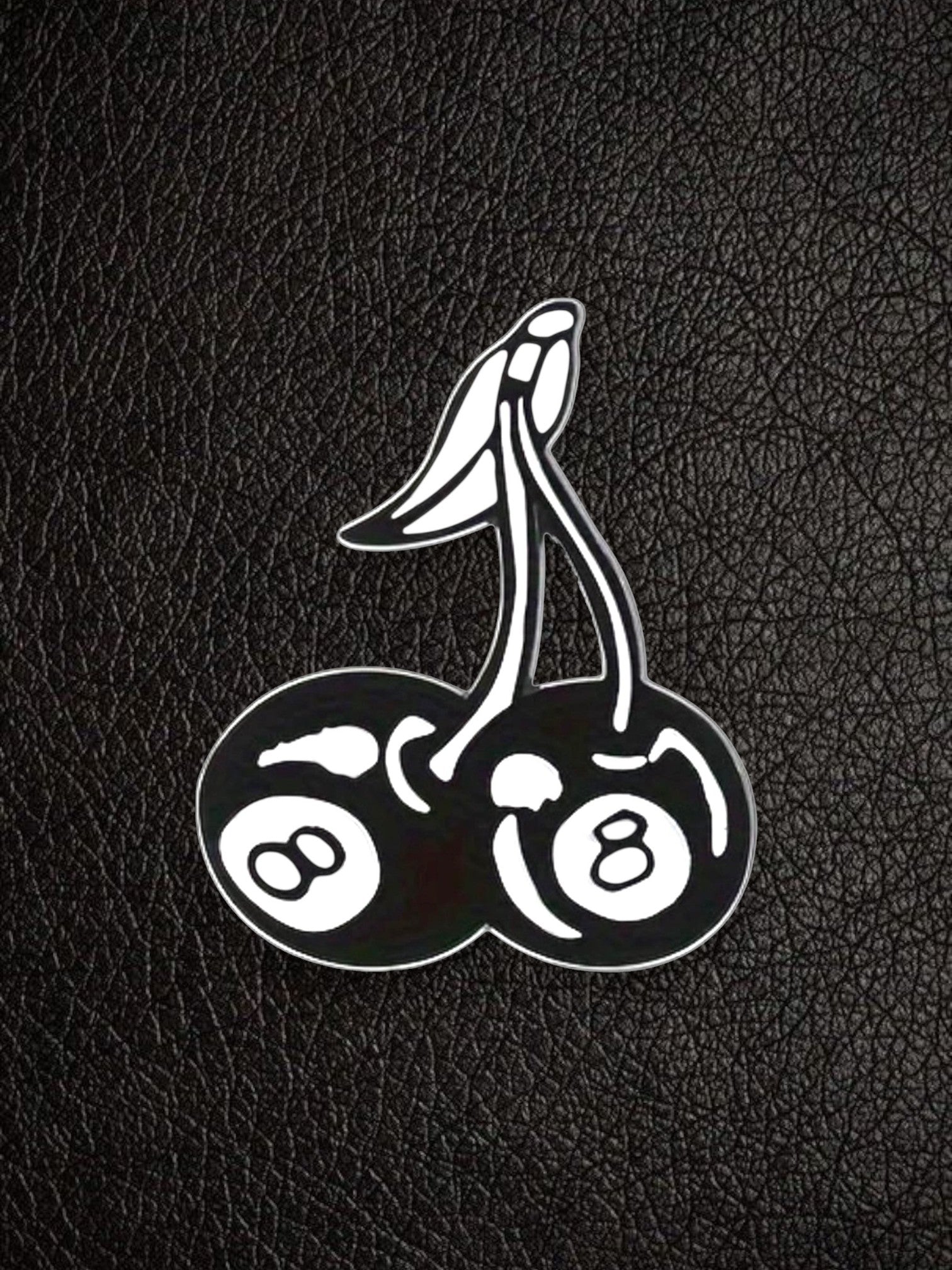 WILDSIDE black and white enamel pin shaped like cherries with 8-ball designs on each cherry.