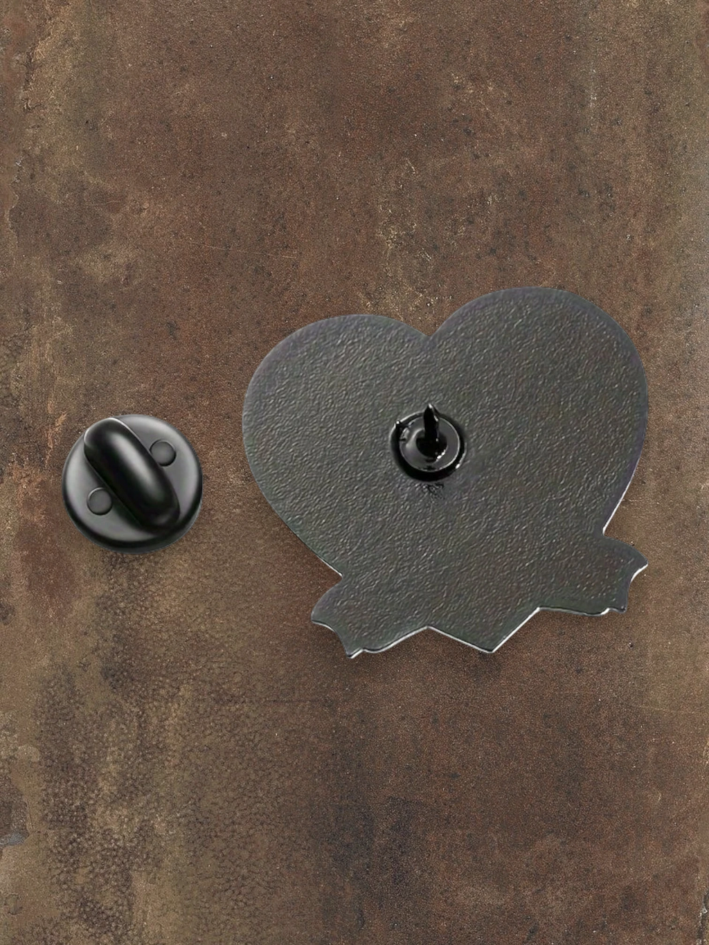 WILDSIDE Addams Family heart-shaped pin with a jagged edge, featuring a black metal backing and pin closure.