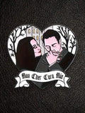 WILDSIDE Addams Family heart-shaped enamel pin featuring Morticia and Gomez with a gothic house and trees. "Mon Cher Cara Mia" banner.