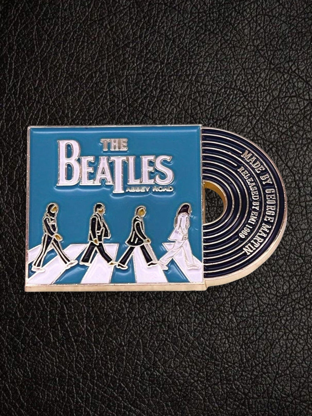 WILDSIDE The Beatles Abbey Road enamel pin featuring the iconic album cover art with the Fab Four crossing the road. Attached to a miniature record.