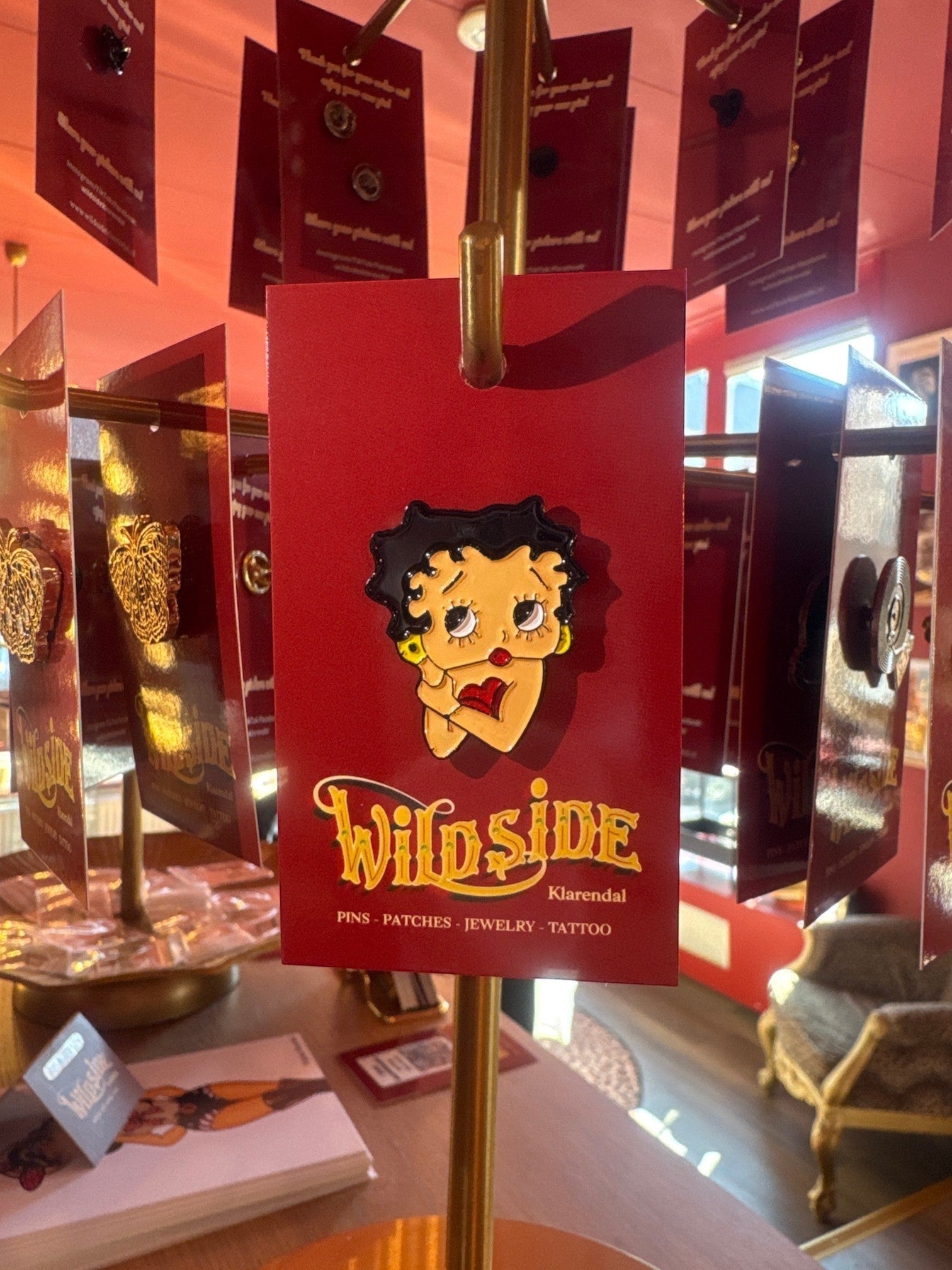WILDSIDE Betty Boop enamel pin with black hair, red lips, and yellow earrings.