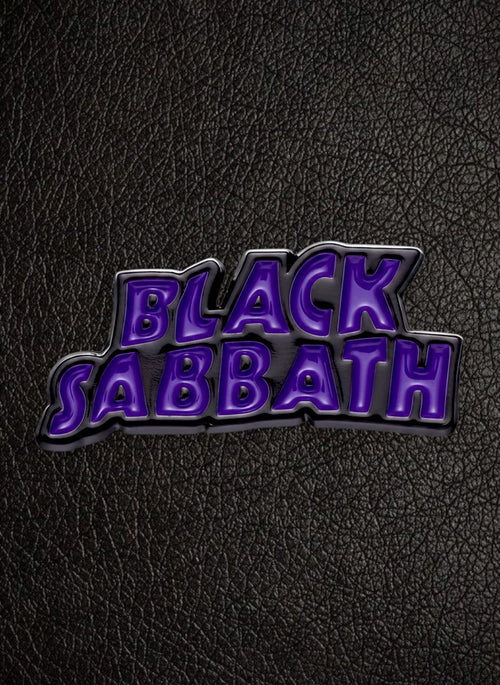 WILDSIDE Black Sabbath purple and black enamel pin with metallic silver border on a rusty metal background.