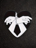 WILDSIDE black and white heart hands bondage pin with glossy enamel finish.