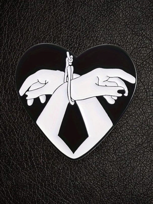 WILDSIDE black and white heart hands bondage pin with glossy enamel finish.