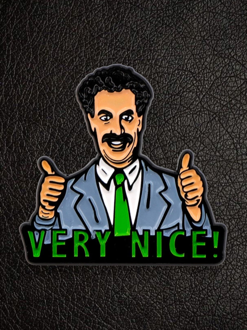 WILDSIDE Borat enamel pin with "Very Nice!" text and two thumbs up, grey suit, green tie.