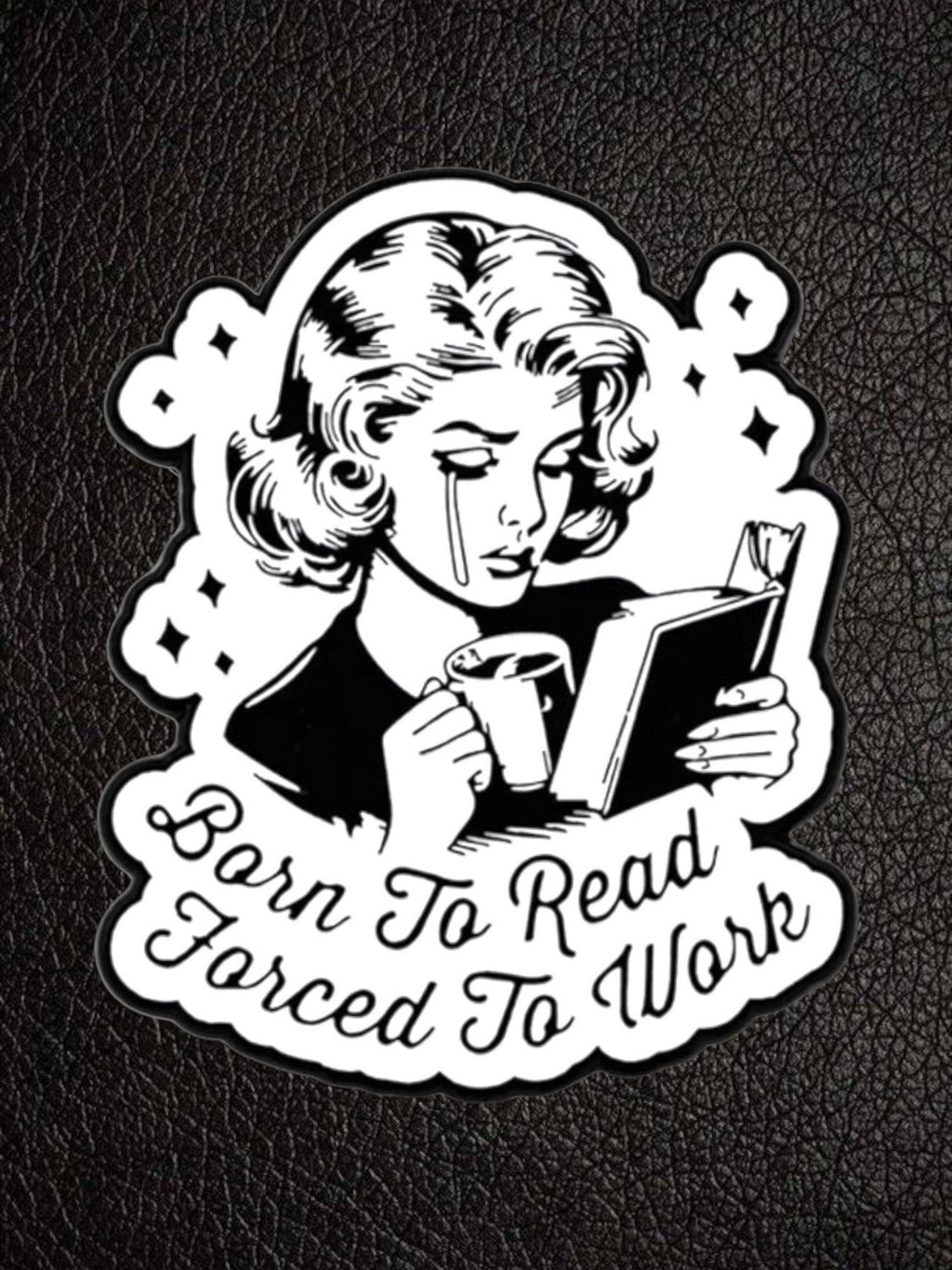 WILDSIDE black and white pin featuring a crying woman reading a book and holding a coffee cup, with text "Born To Read Forced To Work".