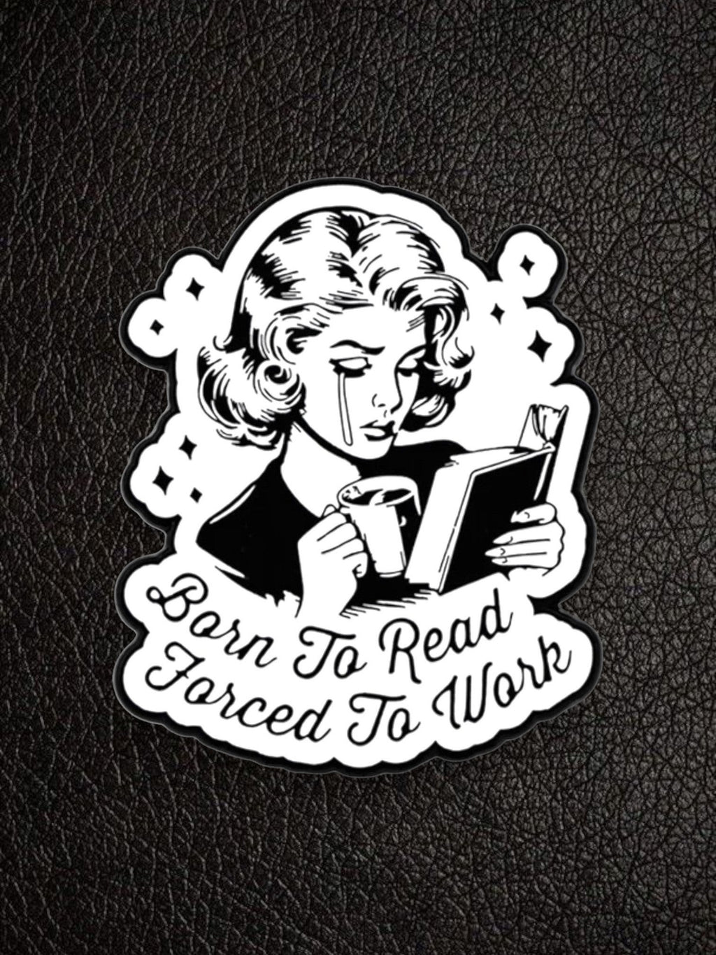 WILDSIDE black and white pin featuring a crying woman reading a book and holding a coffee mug, with text "Born to Read Forced To Work".