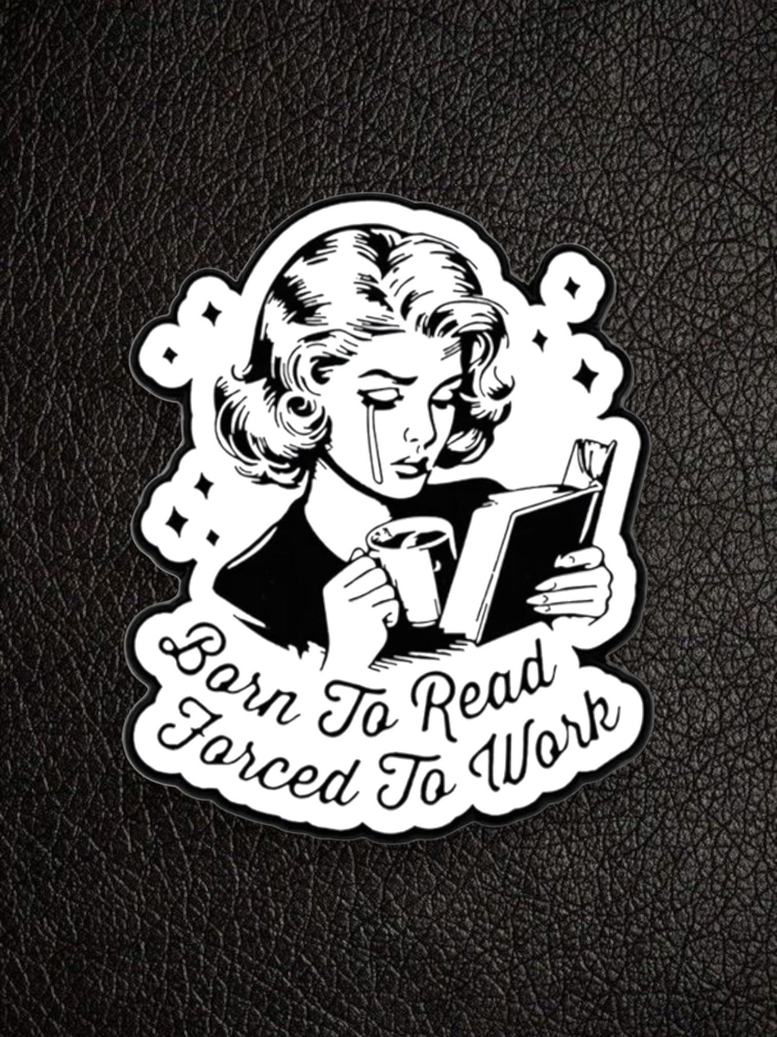 WILDSIDE black and white pin featuring a crying woman reading a book and holding a coffee mug, with text "Born to Read Forced To Work".