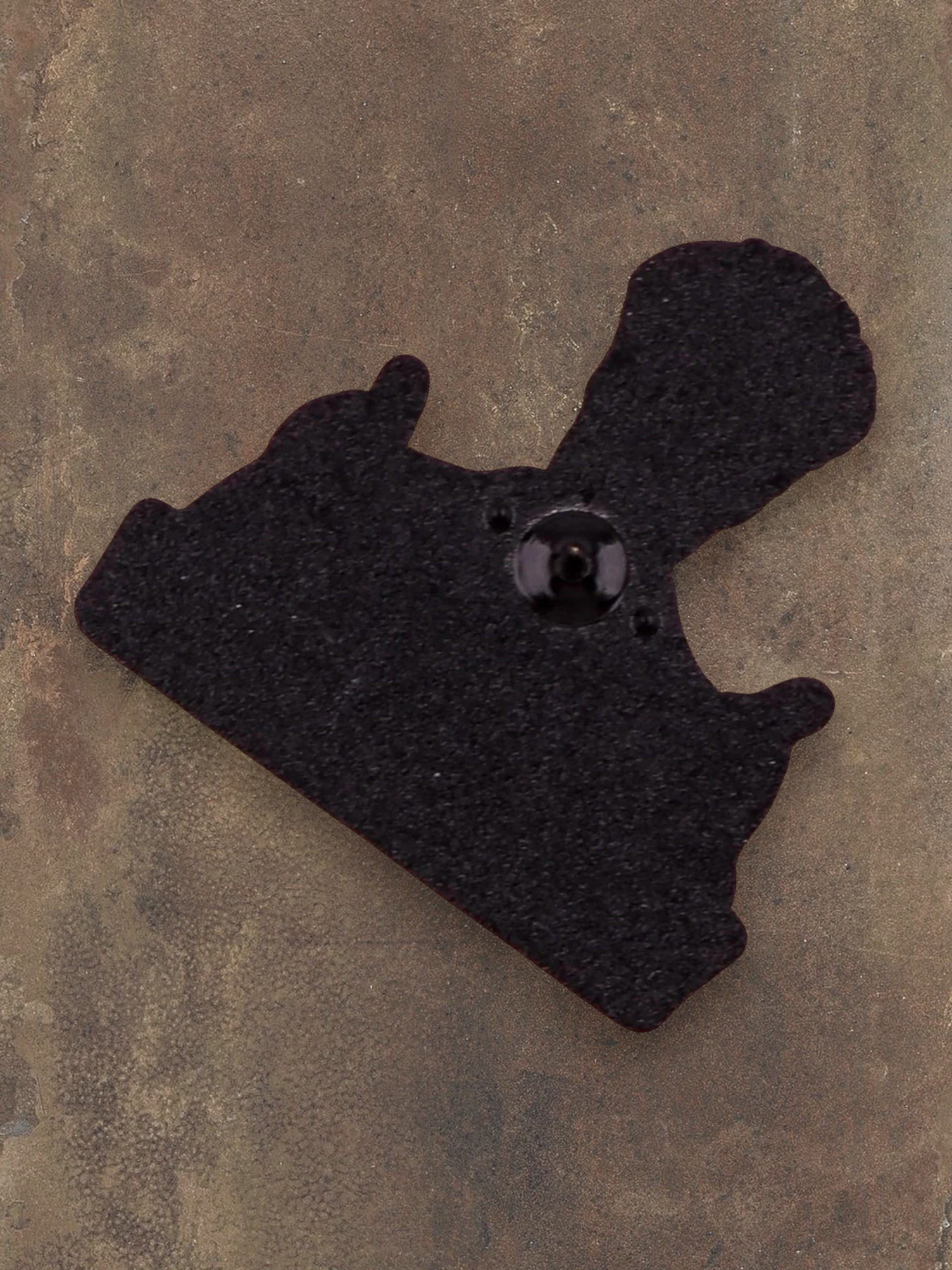 WILDSIDE Borrat enamel pin with two thumbs up, black and brown.