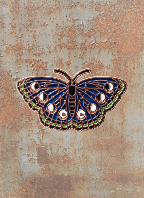 WILDSIDE dark blue butterfly enamel pin with moon phases and stars design.