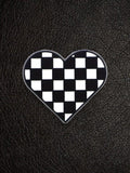 WILDSIDE checkerboard heart pin with black and white squares, perfect for jackets and bags.