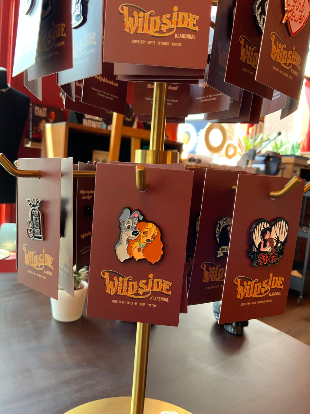 WILDSIDE enamel pin featuring Disney dogs Lady and the Tramp embracing. Metal pin with colourful design.