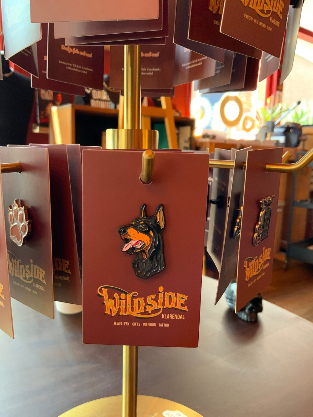 WILDSIDE Doberman dog enamel pin with black and tan markings and tongue out, displayed on a burgundy card.