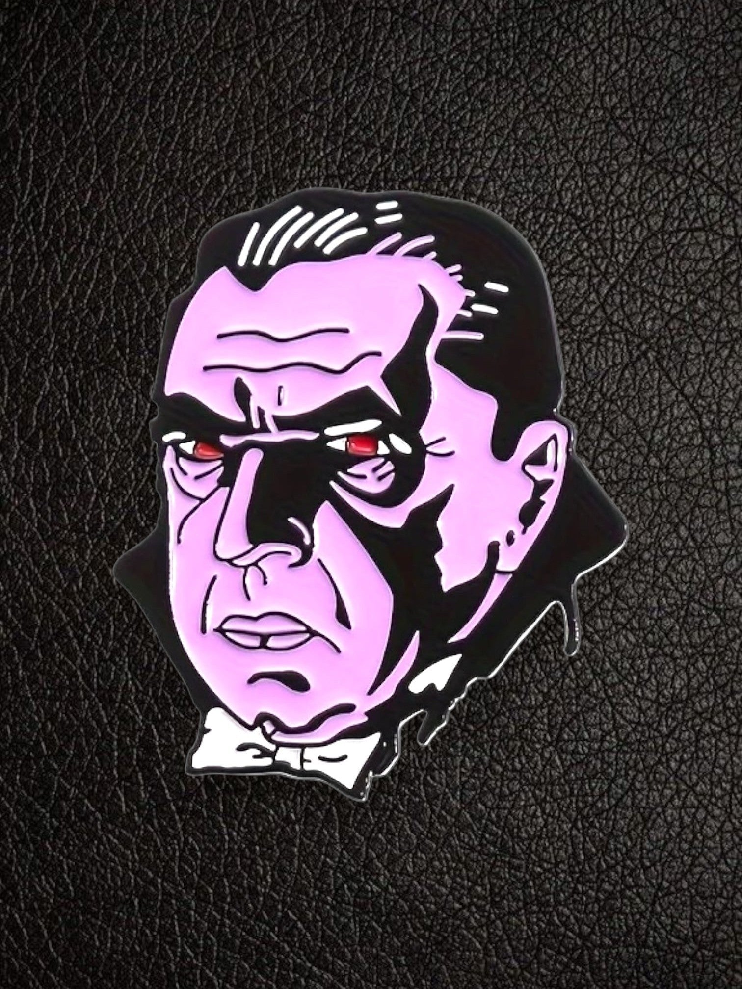 WILDSIDE Classic Dracula monster enamel pin in pink, black, and red with red eyes and a white bow tie.