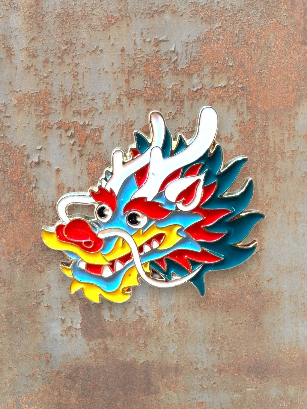 WILDSIDE enamel dragon head pin with blue, red, yellow, and white details. Perfect for jackets and bags.