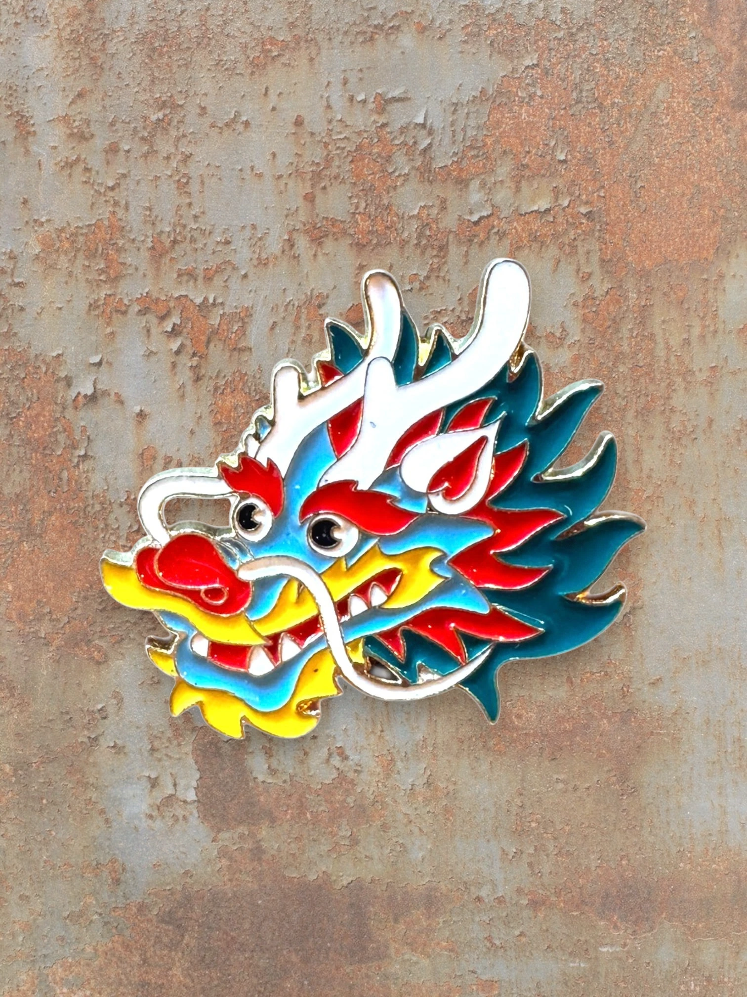 WILDSIDE enamel dragon head pin with blue, red, yellow, and white details. Perfect for jackets and bags.