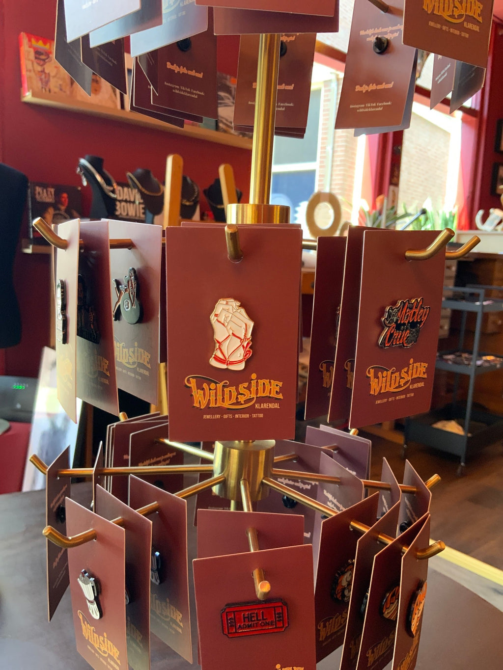 WILDSIDE display of enamel pins featuring punk and rock designs like a fist, guitar, and ticket stub.