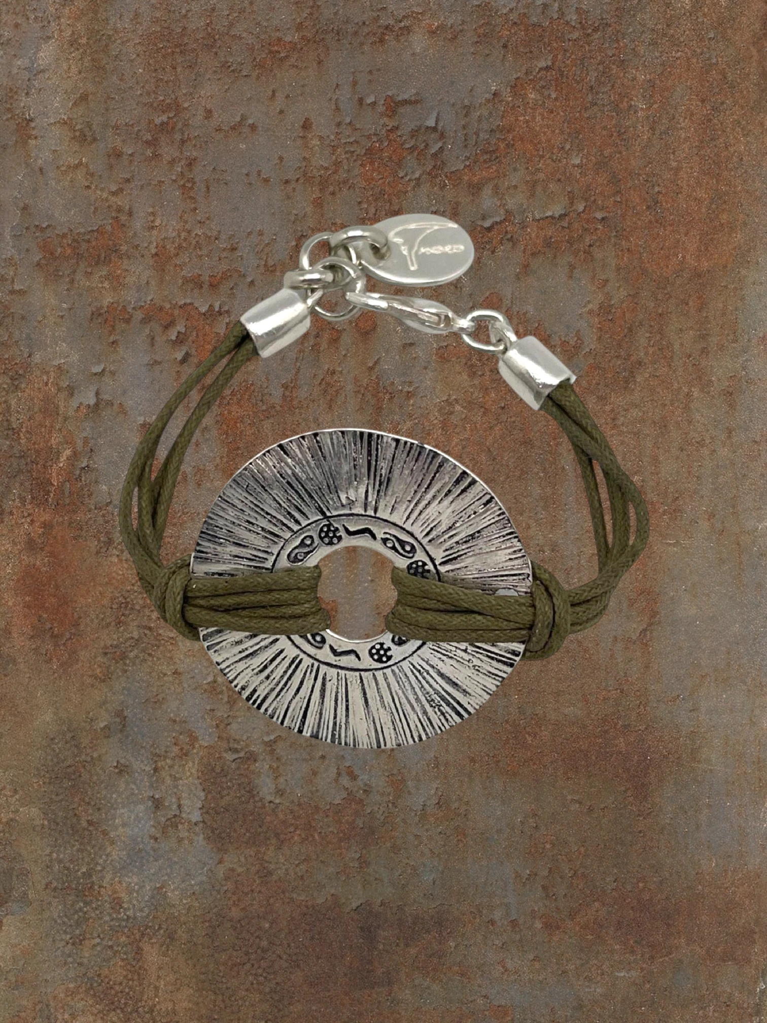 WILDSIDE Etnia bracelet featuring a silver-plated textured disc on a khaki cotton cord with a lobster clasp.
