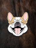 WILDSIDE enamel pin of a laughing French Bulldog with tan and white fur, pink ears, and a black nose, set against a dark brown textured background.