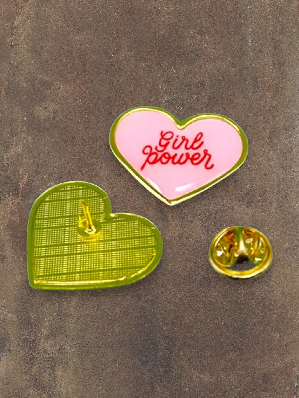 WILDSIDE pink heart enamel pin with red 'Girl power' text and gold trim. Back view shows green textured design.