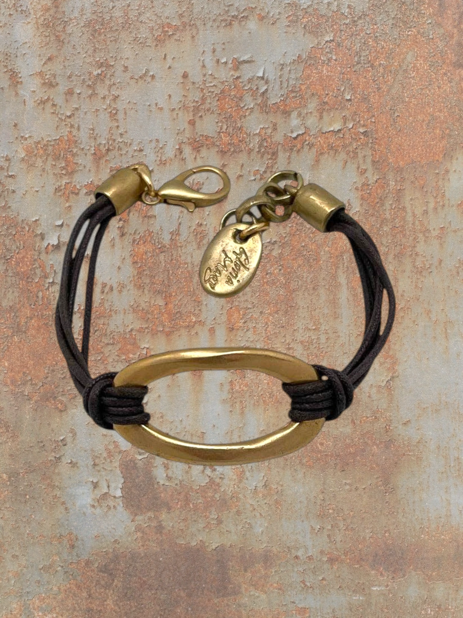 WILDSIDE gold oval link bracelet with dark brown cord, adjustable clasp, and oval charm.
